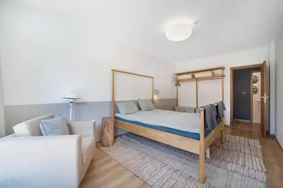 a bedroom with a bed and a couch at Host2U New Inn 2 BD, Fireplace, Free parking in Bansko