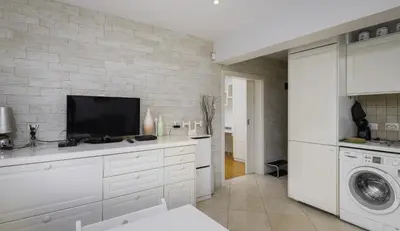 a kitchen with white cabinets and a tv at Bright & Cozy 1BD Apartment close to South Park by Flat Mаnager in Sofia