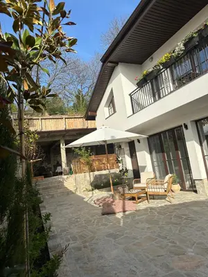 a house with a patio with a table and an umbrella at Stylish Two Bedroom Family Villa in Sopot