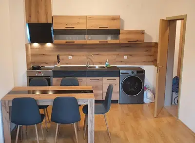 a kitchen with a table and chairs and a sink at South Mountain Apartment in Razlog