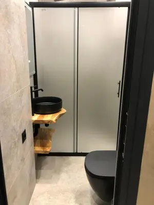 a bathroom with a black toilet and a sink at Stylish 2BDR apartment Gramada, free parking in Sofia