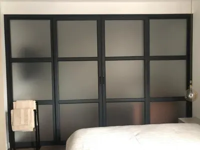 a closet with four glass doors in a bedroom at Stylish 2BDR apartment Gramada, free parking in Sofia