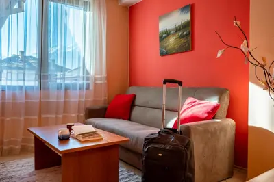 a living room with a couch and a table with a suitcase at Chalet Bizet cosy home in BANSKO in Bansko
