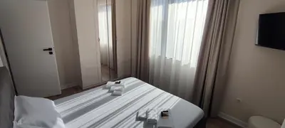 a white bed in a room with a window at Grandma Anni's House in Plovdiv
