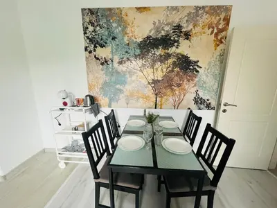 a dining room table with chairs and a painting on the wall at PARK ESCAPE Holiday Home 24h check in in Sandanski
