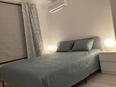 a bedroom with a bed with two lamps and a window at PARK ESCAPE Holiday Home 24h check in in Sandanski