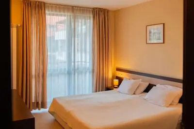 a hotel room with a bed and a large window at Apartment Dream Bansko- 5 min walk to Gondola in Blagoevgrad