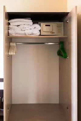 a closet with towels and a microwave on a shelf at Apartment Dream Bansko- 5 min walk to Gondola in Blagoevgrad