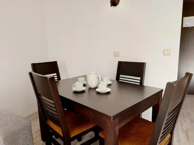 a dining room table with cups and saucers on it at Dream apart-hotel, duplex apartment in Bansko