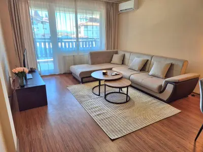 a living room with a couch and a table at Apartment Melania in Complex Royal Towers in Bansko