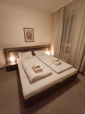 a bedroom with a large bed with two towels on it at Apartment Melania in Complex Royal Towers in Bansko