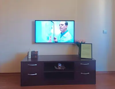 a flat screen tv on a wall above a dresser at Apartment Melania in Complex Royal Towers in Bansko