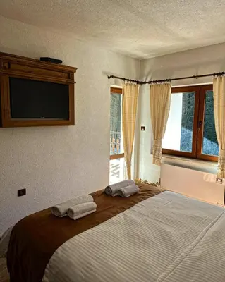 a bedroom with a large bed with two towels on it at Вила Тиара in Stoykite