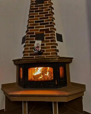 a fireplace with a fire inside of it at Вила Тиара in Stoykite