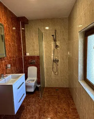 a bathroom with a shower and a toilet and a sink at Вила Тиара in Stoykite