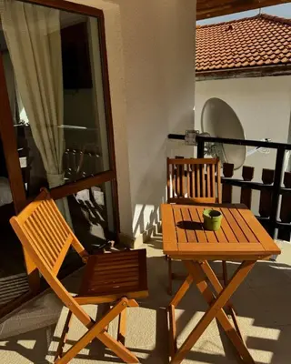two wooden chairs and a table on a balcony at Вила Тиара in Stoykite