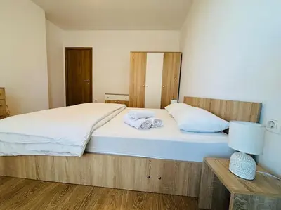 a bedroom with a large bed with white sheets at Bright New Apartment With Parking At The Center! in Sofia