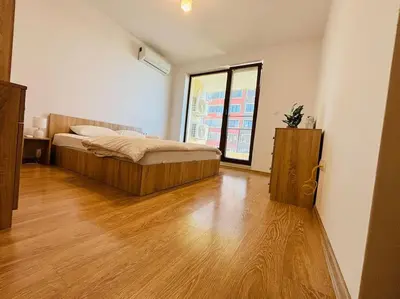 a bedroom with a bed and a wooden floor at Bright New Apartment With Parking At The Center! in Sofia