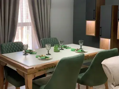 a dining room table with green chairs and a white table and chairsktop at Green Paradise - Luxurious Apartments in Plovdiv