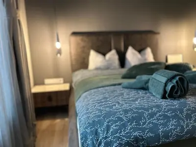 a bedroom with a bed with blue sheets and pillows at Green Paradise - Luxurious Apartments in Plovdiv