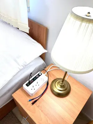 a lamp and a remote control on a table next to a bed at Mountain View, Grand Monastery Pamporovo, top location in Pamporovo