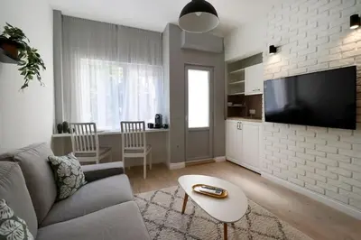 a living room with a couch and a flat screen tv at Urban Chic Sofia Top Central Location in Sofia