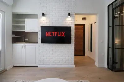 a kitchen with a netflix sign on a white brick wall at Urban Chic Sofia Top Central Location in Sofia