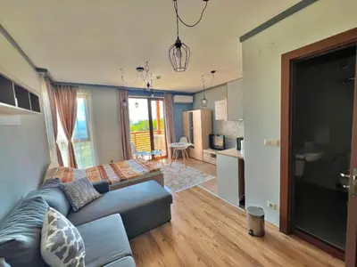 a living room with a couch and a kitchen at St Ivan Ski and Spa Studio in Bansko