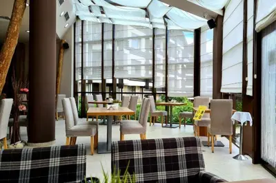 a restaurant with tables and chairs and windows at Cozy apartmen with Mountain view in Bansko