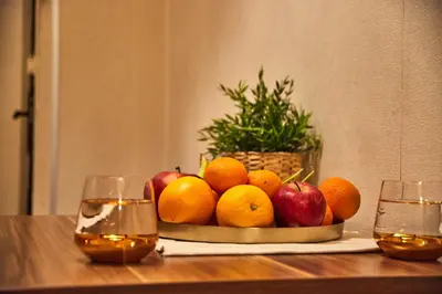 a bowl of fruit on a table with two glasses at Central Luxury Cozy Modern Apartment in Sofia