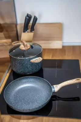 a frying pan and a pot on a stove at Host2U Penthouse Sauna, Jacuzzi, Fireplace in Bansko