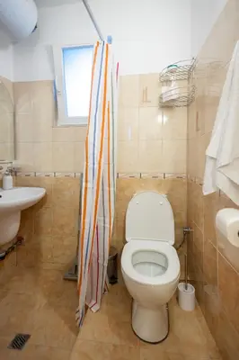 a bathroom with a toilet and a sink at Groovy Olive Apartment in Troyan
