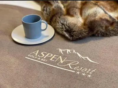 a cat laying on the floor with a cup and saucer at Aspen golf & Ski resort 2 bedroom apartment E002 in Razlog