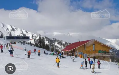 a group of people skiing in the snow near a ski lodge at Aspen golf & Ski resort 2 bedroom apartment E002 in Razlog