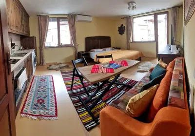 a kitchen and living room with a table and a couch at Mountain View Home Maggie in Bansko