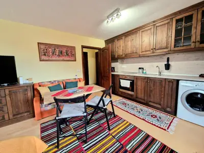 a kitchen with a table and chairs and a couch at Mountain View Home Maggie in Bansko