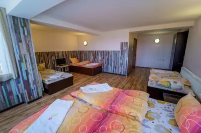 a hotel room with two beds and a couch at Вила Горски Кът in Yavrovo