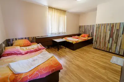 a room with two beds and a bench in it at Вила Горски Кът in Yavrovo