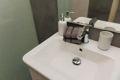 a bathroom with a white sink and a mirror at Elit Park apartment Bright & Cozy in Plovdiv