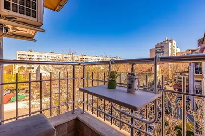 a balcony with a table and a view of a city at City Center Apartment Aleko Konstantinov in Plovdiv
