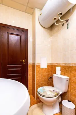 a bathroom with a toilet and a brown door at City Center Apartment Aleko Konstantinov in Plovdiv