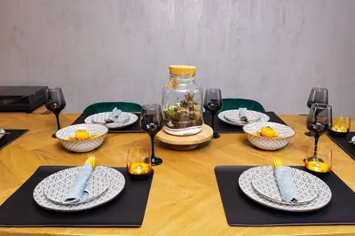 a table with plates of food and wine glasses at Casa di Marko Stylish apt in the Center in Plovdiv