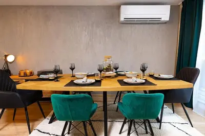 a dining room with a table with green chairs at Casa di Marko Stylish apt in the Center in Plovdiv