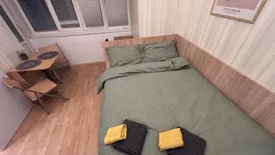 a small bed in a room with a table at Studio in the heart of Sofia in Sofia