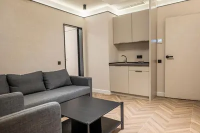 a living room with a couch and a table and a kitchen at M star rooms, Private Parking, Sofia TOP CENTER in Sofia