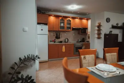 a kitchen with wooden cabinets and a table and chairs at Apartment Rhea with Terrace & Parking in Plovdiv