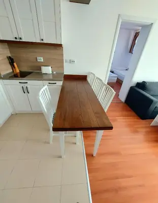 a kitchen with a wooden table and white chairs at BELVEDERE Holiday Club VIP 59 in Bansko