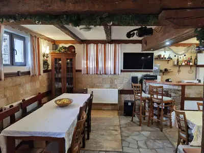 a kitchen and dining room with a table and chairs at Mira Guest House in Dobrinishte
