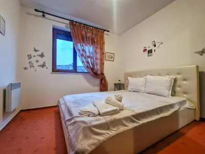 a bedroom with a bed with towels on it at Cozy 2-Bedroom Stay with Parking in OLD INN Bansko by Flat Mаnager in Bansko