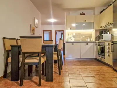 a kitchen and dining room with a table and chairs at Cozy 2-Bedroom Stay with Parking in OLD INN Bansko by Flat Mаnager in Bansko